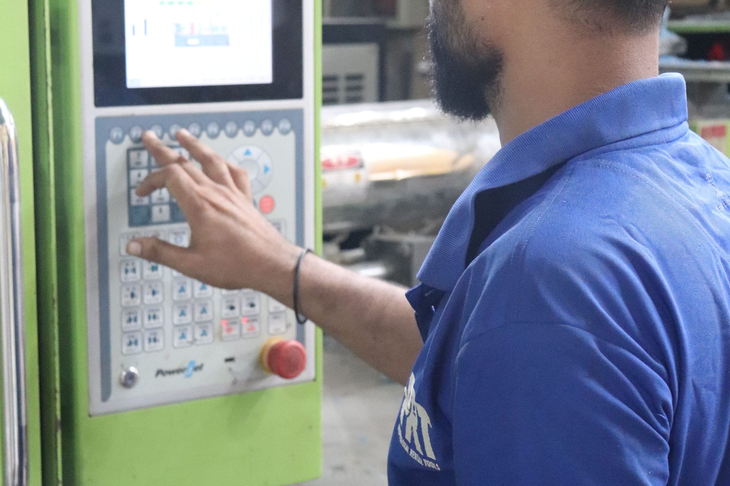 Operator at the control panel of a factory moulding machine